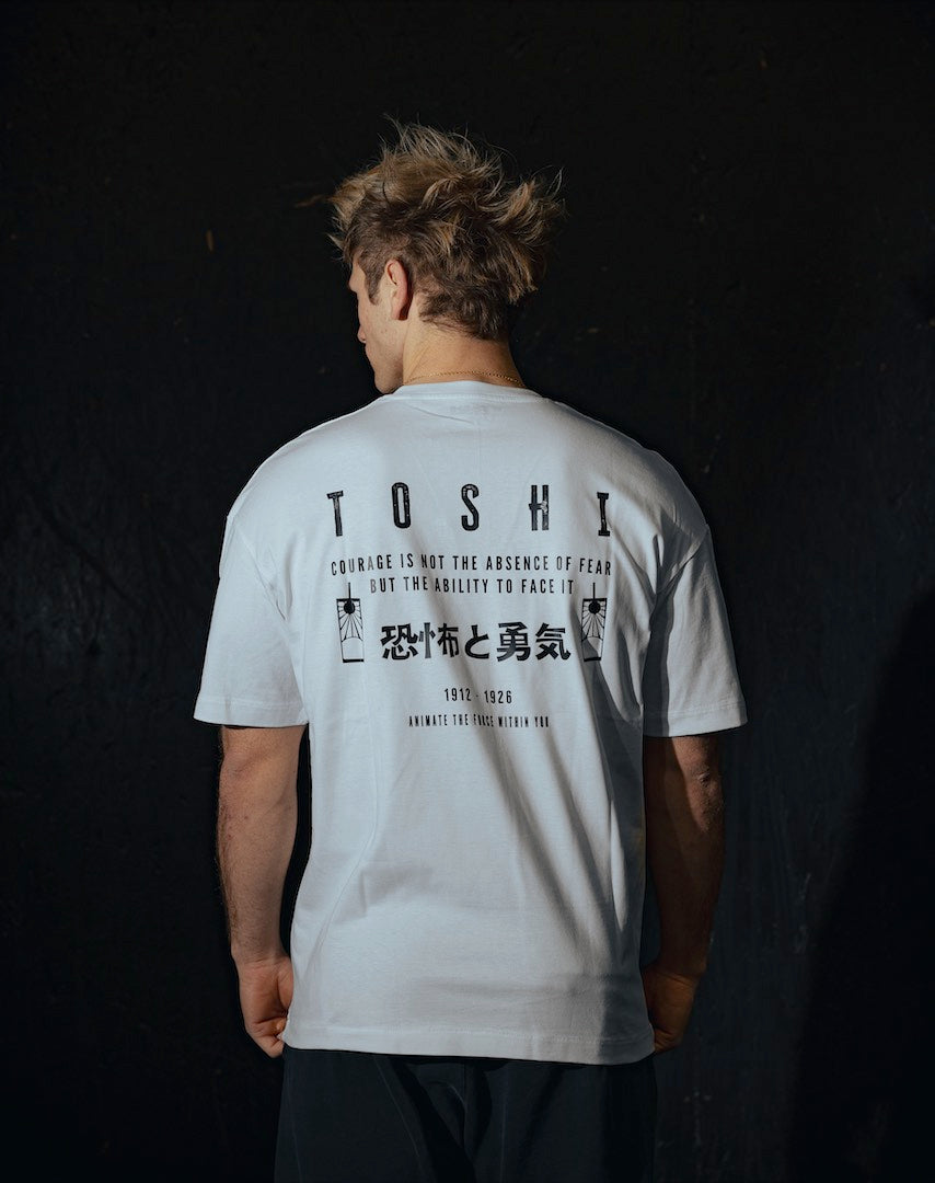 T-shirt oversize blanc TOSHI “Fear and Courage” pour homme, inspiré de l’univers de Demon Slayer, style manga japonais et streetwear sportif.
