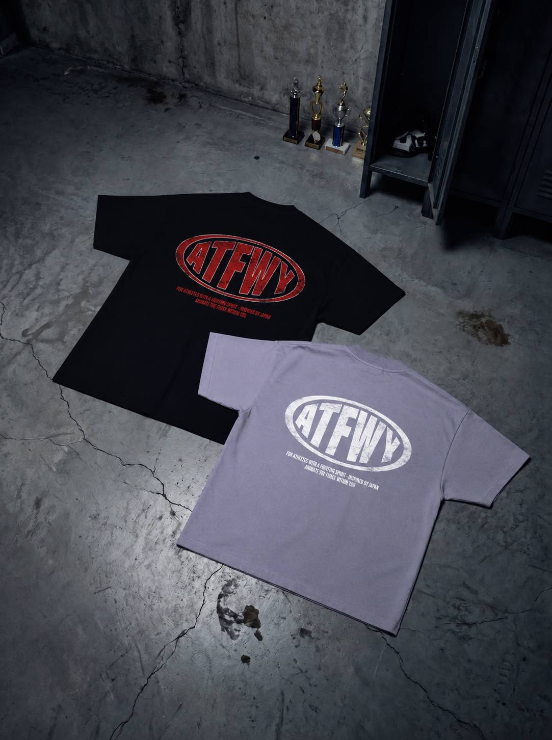 T-shirt oversize de couleurs noire et violette présentés à plat de dos, avec un visuel des lettres ATFWY en rouge, destiné aux athlètes et inspiré de la culture japonaise.