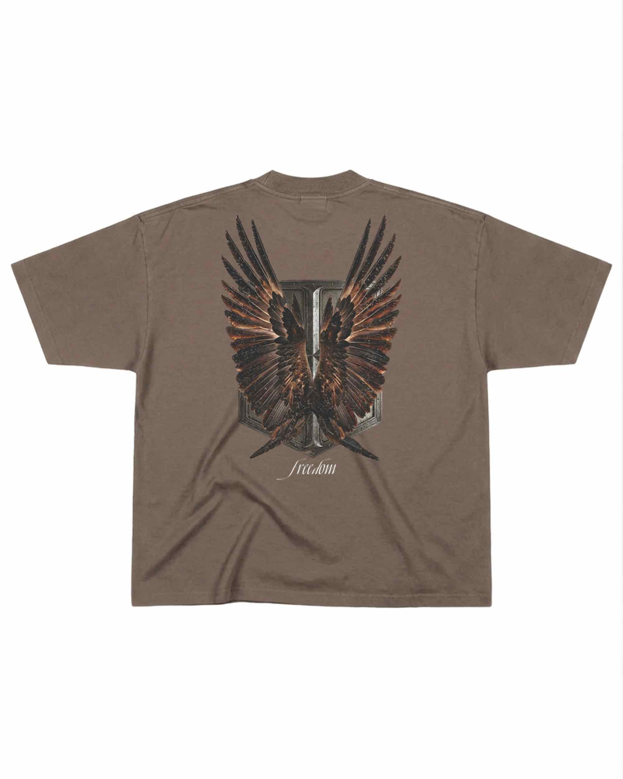 T-shirt oversize de couleur mocha présenté à plat de dos avec un visuel inspiré de l’anime l’Attaque des Titans, représentant un bouclier et des ailes.