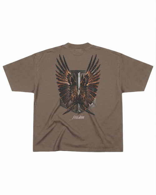 T-shirt oversize de couleur mocha présenté à plat de dos avec un visuel inspiré de l’anime l’Attaque des Titans, représentant un bouclier et des ailes.
