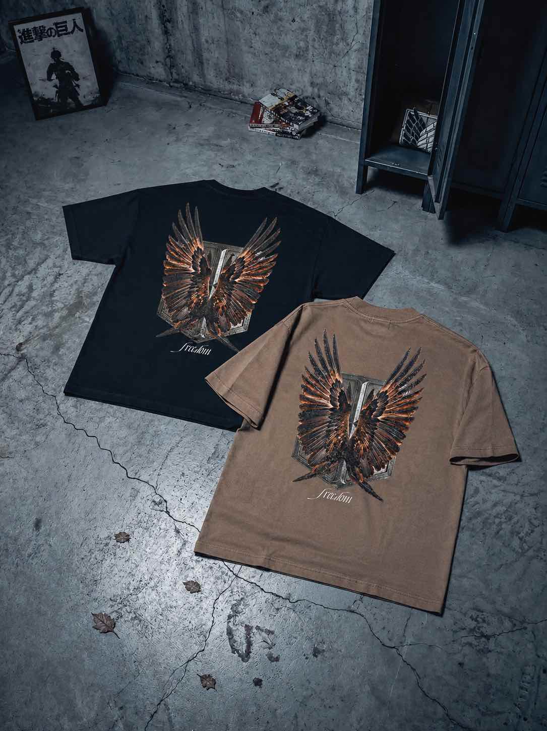 T-shirts oversize de couleurs mocha et noire présentés à plat de dos avec un visuel inspiré de l’anime l’Attaque des Titans, représentant un bouclier et des ailes.