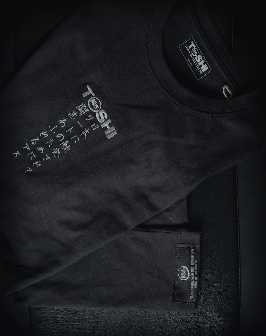 T-shirt oversize noir TOSHI “Mantra” pour homme, inspiré des mangas et animes japonais, style streetwear premium avec broderie et étiquette tissée.