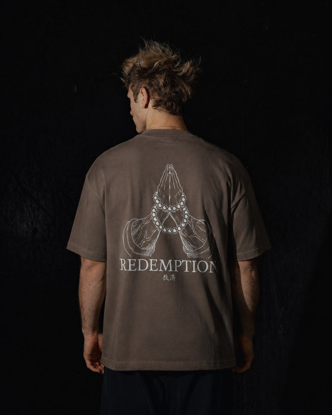 Homme de dos portant un t-shirt oversize de couleur mocha, avec un visuel inspiré de l’anime demon slayer, représentant les mains du pilier Gyomei.