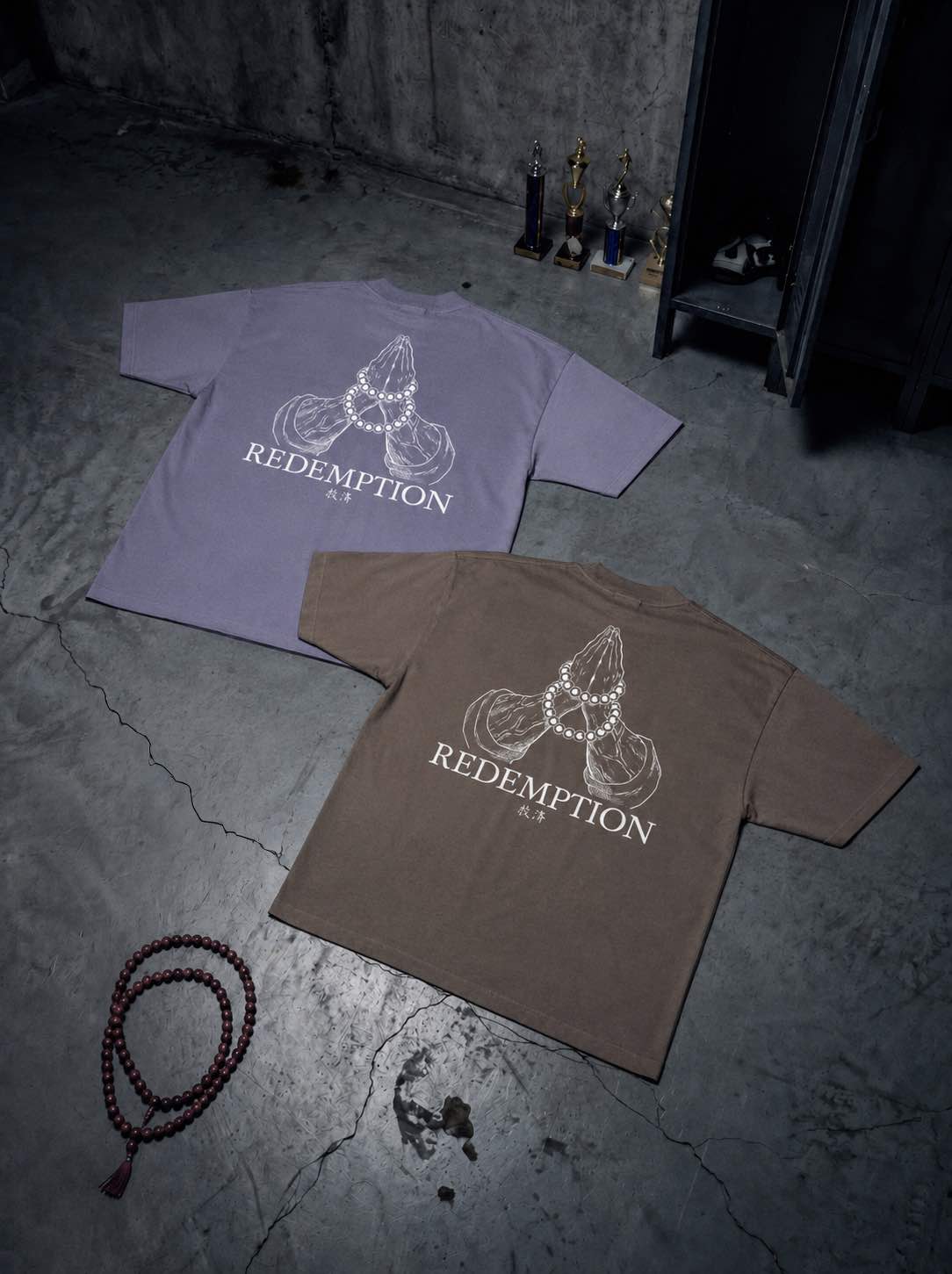 T-shirts oversize de couleurs violette et noire présentés à plat de dos avec un visuel inspiré de l’anime demon slayer, représentant les mains du pilier Gyomei.