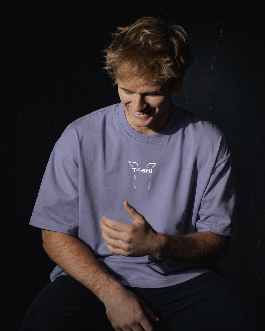 Homme de face portant un t-shirt oversize de couleur violette, avec un logo japonais de la marque TOSHI inspiré de l'anime demon slayer.